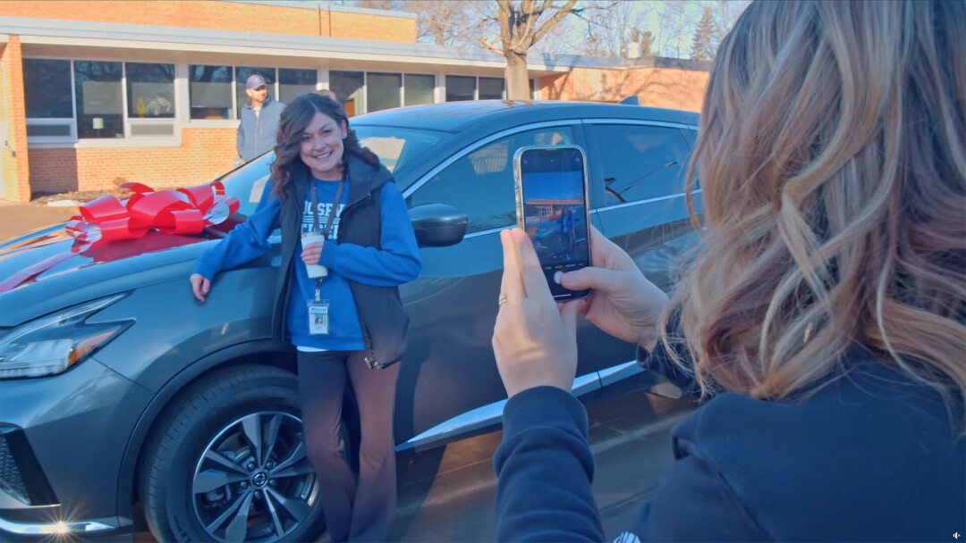 Sarah Candell pictured with the new-to-her vehicle after being surprised at Roosevelt Elementary.