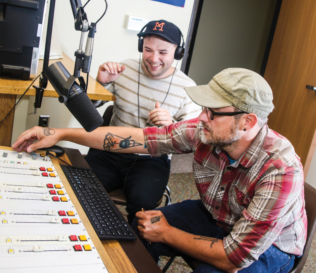 In thier cramped studio space, Blugold Radio station manager Scott Morfitt (right) works the dials while social media manager Jordan Duroe thoroughly enjoys himself.