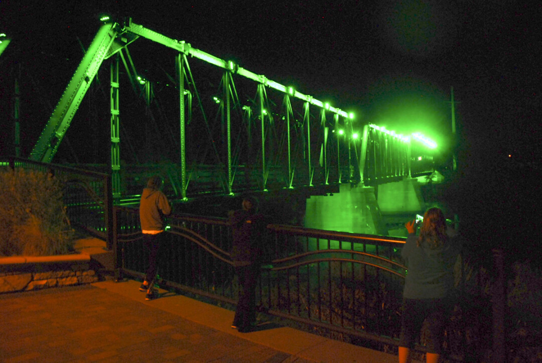 GREEN SCENE. Passersby admire the newly installed LED lights on the Phoenix Park pedestrian bridge. The 172 computer-controlled fixtures are capable of producing 252 million colors. The lights will be officially unveiled in a public performance at 7pm Thursday, Oct. 12. After that, they’ll be illuminated nightly.